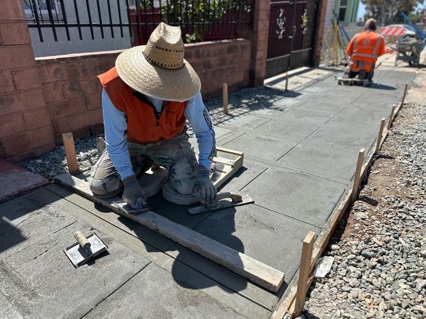 Crew member troweling fresh concrete during a pour